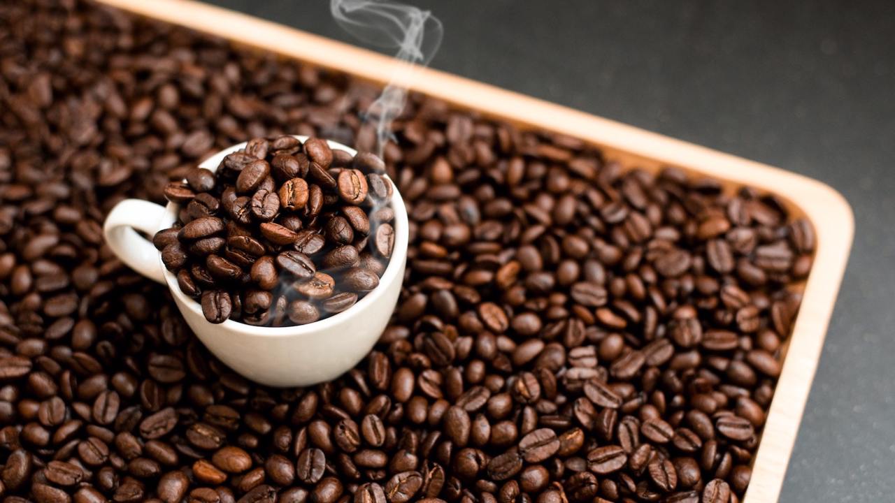 container of coffee beans with a cup of coffee beans